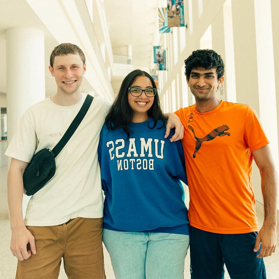 Three UMass Boston students, a woman and two men, smiling